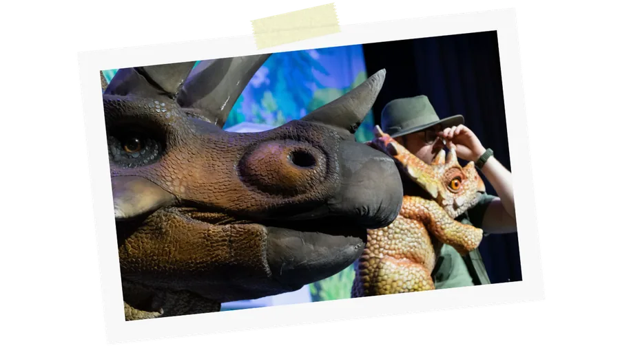 A triceratops and a baby dinosaur on stage